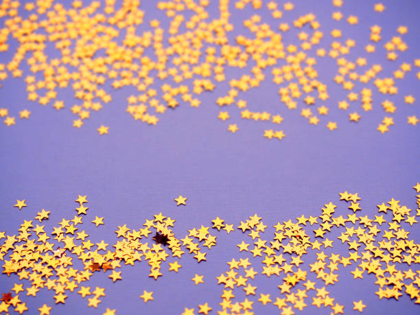 istock Golden stars glitter on lavender paper background 1166511955