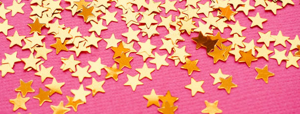 istock Golden stars glitter on pink background 1166511965