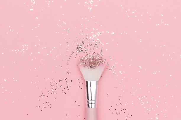 istock Makeup brush and shiny sparkles on pastel pink background. Festive magic makeup concept. Template for design, Top view Flat Lay Copy space 1166512502