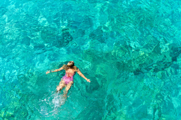 istock Woman floating in immaculate sea. 1166512639