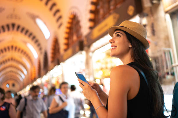Happy woman exploring a grand bazaar using mobile phone, Istambul, Turkey