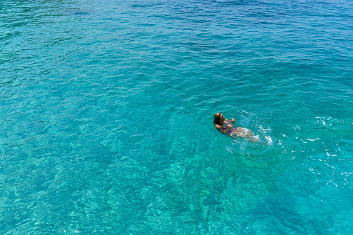 Woman floating in immaculate sea.