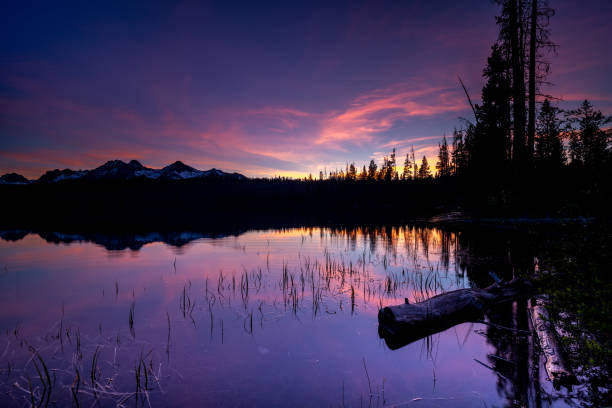 Layers of mountains and hills leading off into the distance with orange colorful clouds lit with sunrise light.