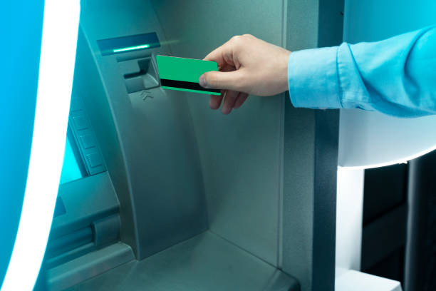 istock man putting credit card in modern ATM machine 1166520542