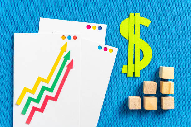 inflation and financial concepts as profitability, taxes, stock market. three cut paper arrows shape showing growing up and cut paper green dollar symbol with graph bar made with wooden blocks, on blue textured background. - green report business bar graph imagens e fotografias de stock