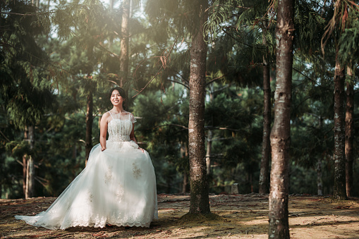 an asian chinese female model dress up with wedding gown for outdoor portrait session at public park in evening