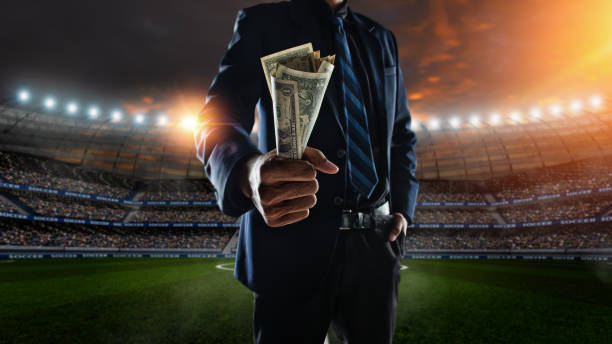 businessman holding large amount of bills at Soccer stadium in background businessman holding large amount of bills at Soccer stadium in background sports betting stock pictures, royalty-free photos & images
