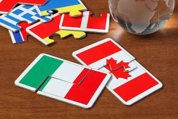puzzle with the national flag of Italy and Canada on wooden table