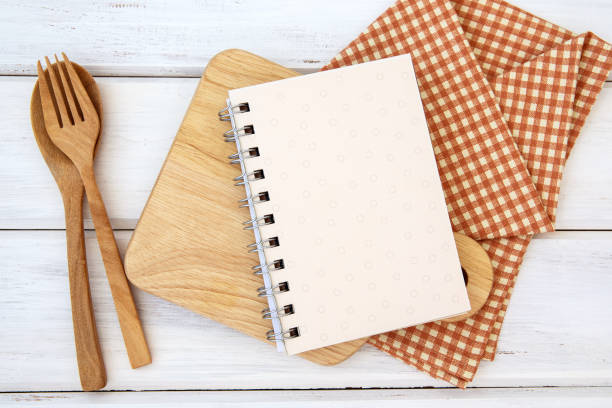 istock book notepad paper on chopping cutting board and tablecloth on white table , a recipes food  for healthy habits shot note background concept 1166535262