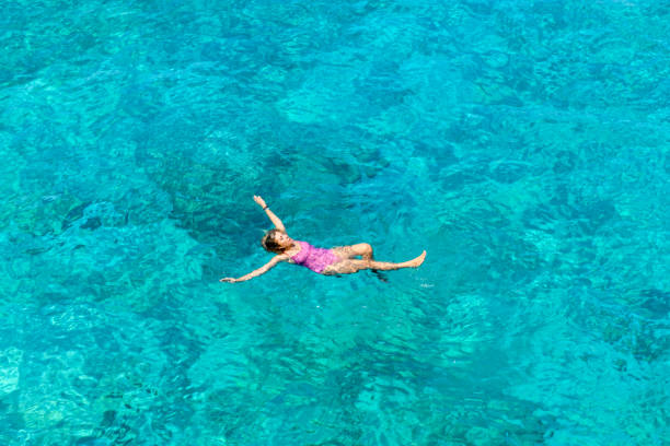 istock Woman floating in immaculate sea. 1166535979