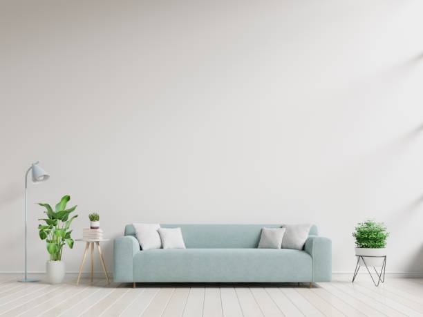 istock Empty living room with blue sofa, plants and table on empty white wall background. 1166536339