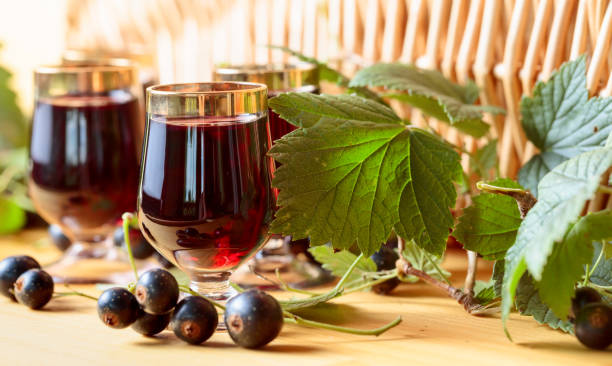 Homemade black currant liqueur and fresh berries. Homemade black currant liqueur and fresh berries, wooden background. casis stock pictures, royalty-free photos & images