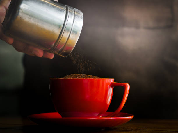 istock Hand sprinkles chocolate powder on drink in red cup. 1166540552