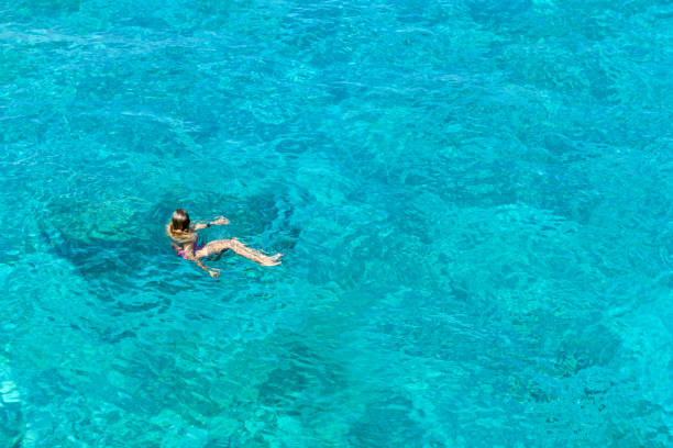 istock Woman floating in immaculate sea. 1166540680