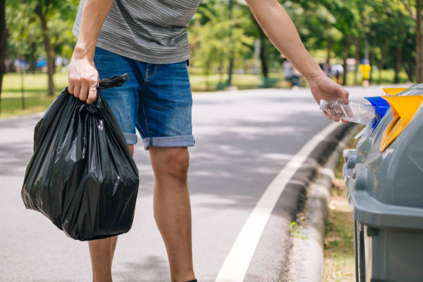 istock Close up of man hand throwing a plastic bottle into recycle dustbin. Garbage sorting before putting in garbage bin 1166541615