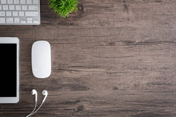 istock The office desk flat lay view with keyboard, mouse, tree and earphone on wood texture background. 1166543486