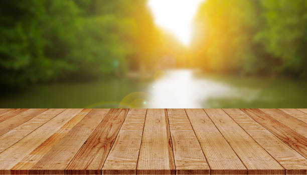 istock wooden board with blurred nature and sunlight background 1166544568