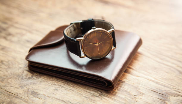 istock Wristwatch with wallet on wooden background. 1166544827
