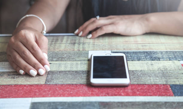 istock Woman sitting in cafe. Smartphone on the table 1166544832