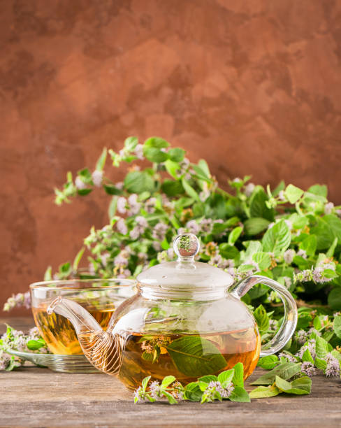 istock Fresh aromatic tea with melissa mint leaves glass teapot on a rustic background. Healing herbal drink. Vertical frame. 1166547711