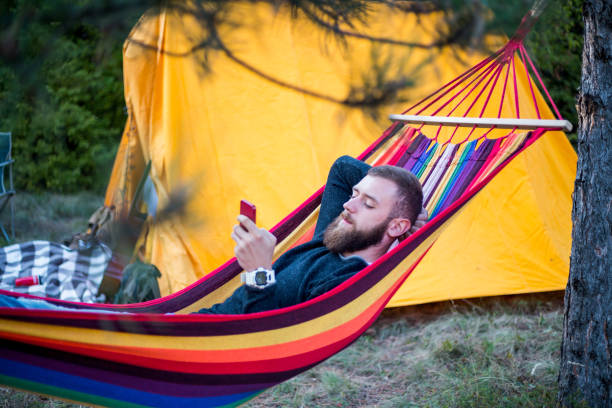 istock Caucasian man lying on hammock in a pine forest. Outdoors relaxation. 1166548902