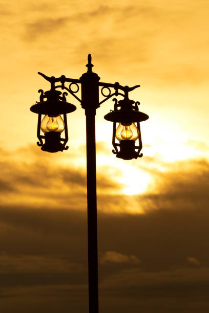 istock silhouette wrought iron street lamp at sunset 1166551377