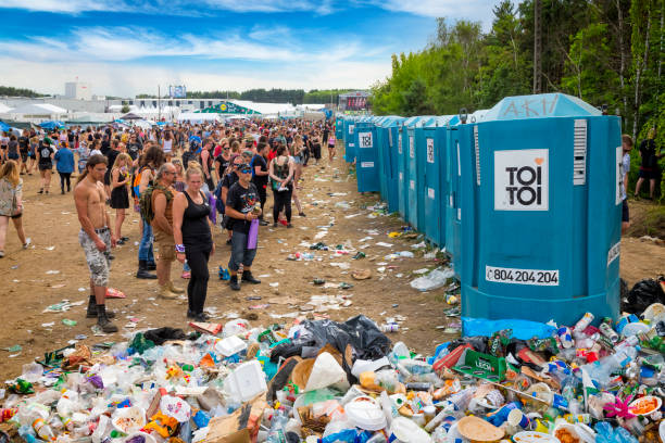 Pol'and'rock Festival 2019, Poland Kostrzyn Nad Odra, Poland - August 02, 2019:Crowd of young people standing in front of portable toilets on the 25th Pol'and'rock Festival - the biggest open air ticket free rock music festival in Europe music festival camping summer vacations stock pictures, royalty-free photos & images