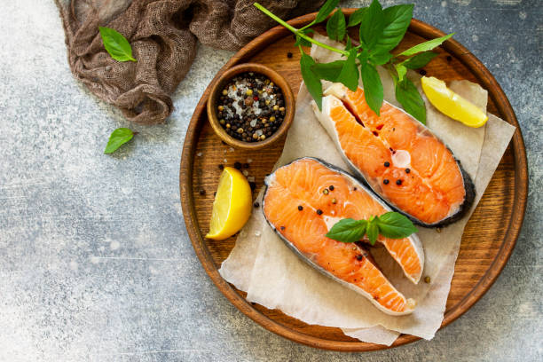 istock Steak raw fish prepared for cooking. Salmon wiht basil and spices on slate table. Top view flat lay. 1166554994