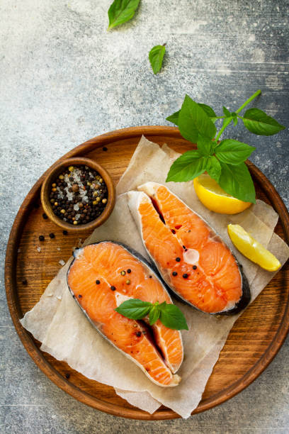 istock Steak raw fish prepared for cooking. Salmon wiht basil and spices on slate table. Top view flat lay. Free space for your text. 1166555004