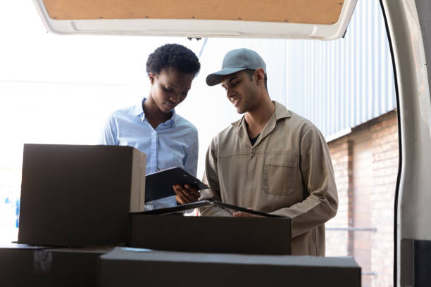 istock Delivery man and warehouse manager discussing over clipboard outside the warehouse 1166555183