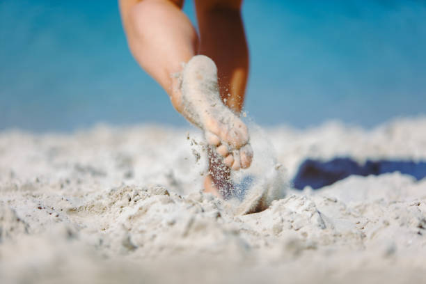 istock woman legs walking by sand beach summer time 1166555844