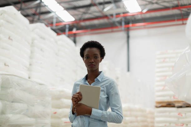 istock Female manager with digital tablet looking at camera in warehouse 1166555970