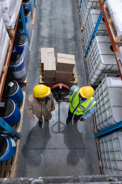 istock Female staff interacting with her coworker in warehouse 1166560329