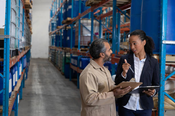 istock Female manager and male worker discussing over clipboard in warehouse 1166560879
