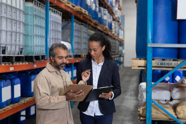 istock Female manager and male worker discussing over clipboard in warehouse 1166560902