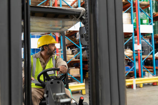 istock Male staff driving forklift in warehouse 1166565035