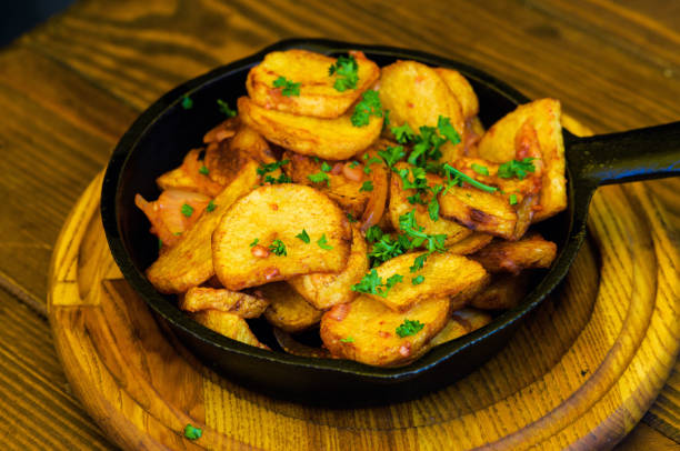 istock baked fried potatoes with garlic on wooden table background 1166566168