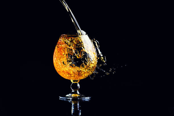 istock glass with cognac with splash on a black background 1166566223