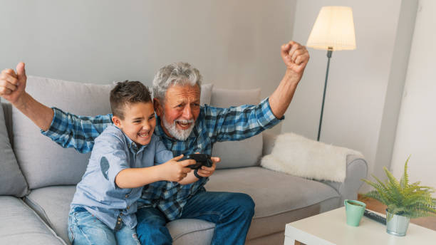 istock Grandfather and child playing game console 1166566392
