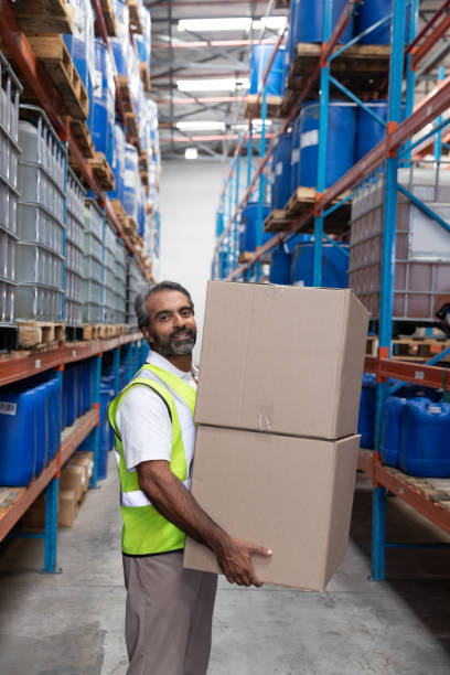 istock Male staff carrying cardboard boxes in warehouse 1166567539