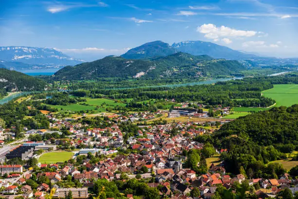 Color photography of high angle view, aerial view of beautiful French natural landscape in Bugey mountains, with small town of Culoz, the Rhone River and famous Lake Bourget in the background in summer. Shot from Grand Colombier mountain top during a sunny summer day, in Bugey mountains, in Ain department not far from Jura and Savoie border near Culoz city, Auvergne-Rhone-Alpes region in France (Europe).