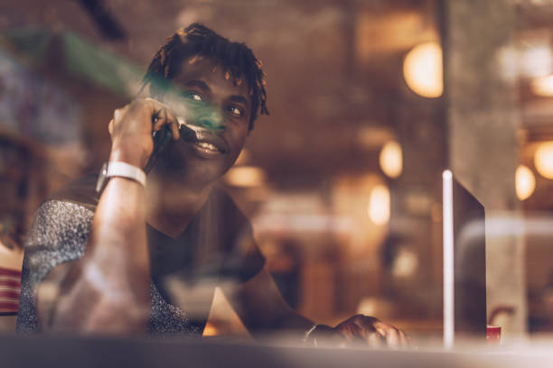 istock Man sitting in coffee shop and multi-tasking 1166573604