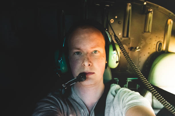 Young man taking a selfie looking at camera shot during a helicopter trip