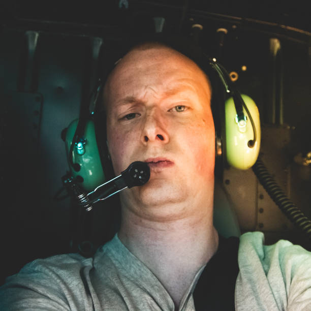 istock Young man taking a selfie grimacing and looking at camera, shot during a helicopter trip 1166574177