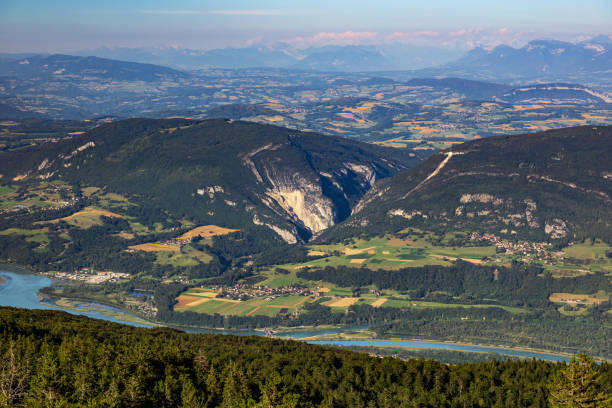 High point of view french hilly landscape on Ain and Jura departments from Grand Colombier mountain, with the end of day sunlight in summer in European Alps Horizontal composition color photography of high point of view rolling landscape on Ain and Jura departments from local landmark Grand Colombier mountain, with the end of day sunlight in summer. Shot from Grand Colombier mountain top in Bugey mountains, in Ain department not far from Jura and Savoie border near Culoz city, Auvergne-Rhone-Alpes region in France (Europe). jura france stock pictures, royalty-free photos & images