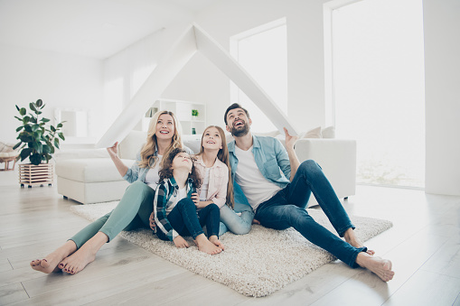 Photo of young family adopted, two children move new apartments hold hands paper roof hoping best future