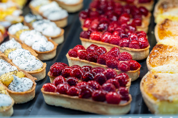 Colorful raspberry cheese tart and fruit tart in patisserie shop