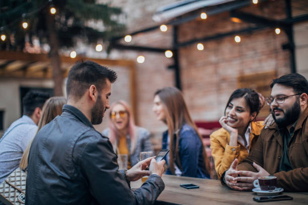 istock Friends sitting together outdoors in cafe 1166577862