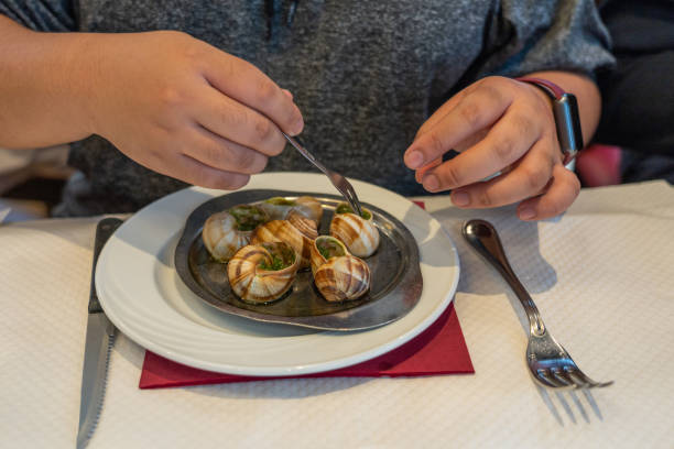 Menschliche Hand mit kleinen Gabel essen Escargots de Bourgogne – Foto