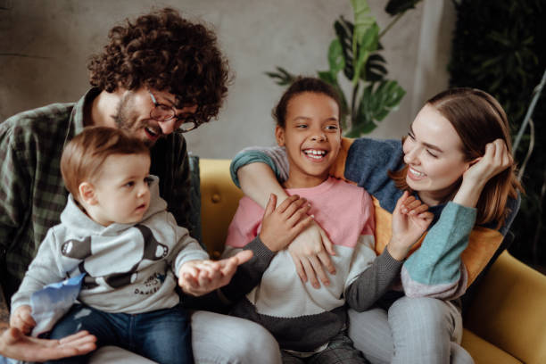 happy family sitting on the couch - acolhimento familiar imagens e fotografias de stock